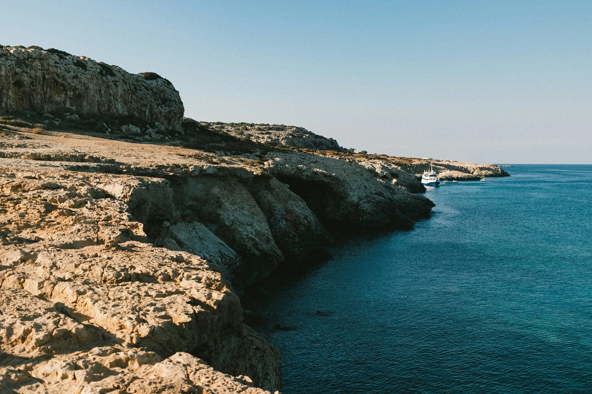 Skalnaté pobrežie a modrá voda Stredozemného mora pri Cape Greco.